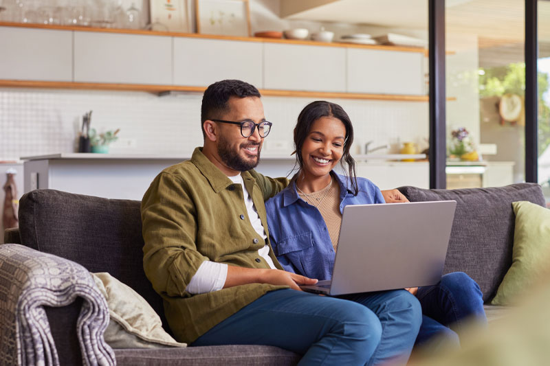 couple-banking-on-couch couple banking on laptop on couch